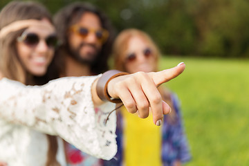 Image showing happy hippie woman pointing finger outdoors