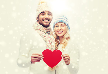 Image showing smiling couple in winter clothes with red heart