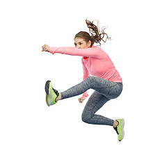 Image showing happy sporty young woman jumping in fighting pose