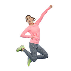 Image showing happy smiling sporty young woman jumping in air