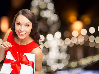 Image showing smiling woman in red dress with christmas gift box