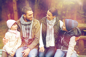 Image showing happy family sitting on bench and talking at camp