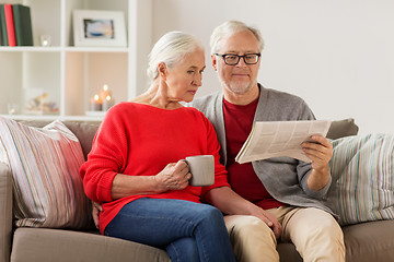 Image showing happy senior couple reading newspaper at christmas