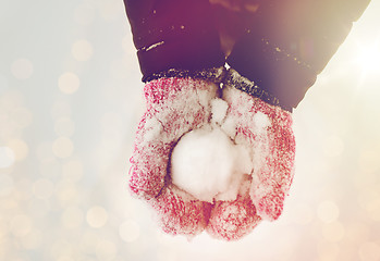 Image showing close up of woman holding snowball outdoors