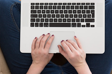 Image showing young woman on sofa at home websurfing