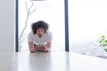 Image showing young man using a tablet at home