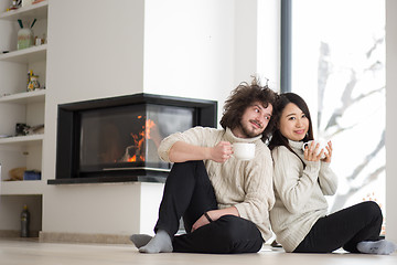 Image showing happy multiethnic couple  in front of fireplace