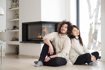 Image showing happy multiethnic couple  in front of fireplace