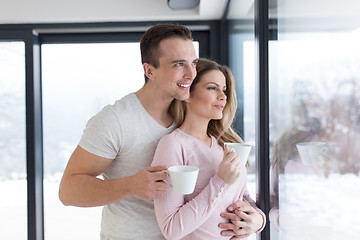 Image showing young couple enjoying morning coffee by the window