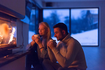 Image showing happy couple in front of fireplace