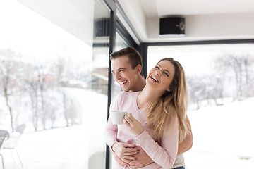 Image showing young couple enjoying morning coffee by the window