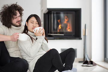 Image showing happy multiethnic couple  in front of fireplace