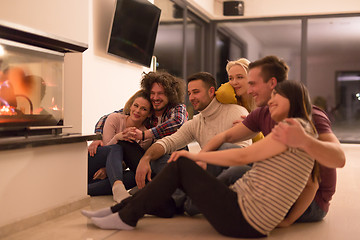 Image showing multiethnic couples sitting in front of fireplace