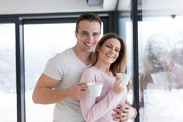 Image showing young couple enjoying morning coffee by the window