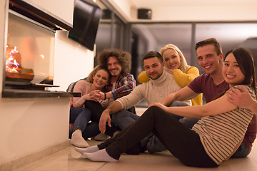 Image showing multiethnic couples sitting in front of fireplace