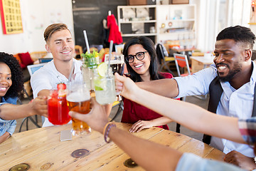 Image showing friends clinking glasses with drinks at restaurant