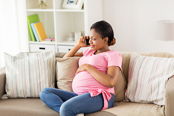 Image showing happy pregnant woman calling on smartphone at home