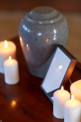 Image showing photo frame, cremation urn and candles on table