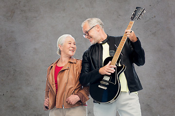 Image showing happy senior couple with electric guitar