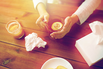 Image showing close up of ill woman drinking tea with lemon