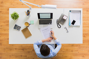 Image showing businesswoman signing contract document at office