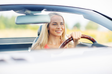 Image showing happy young woman driving convertible car