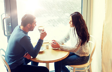 Image showing happy couple drinking tea and coffee at cafe