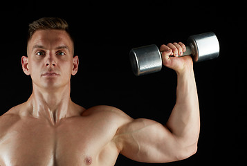 Image showing man with dumbbell exercising over black background