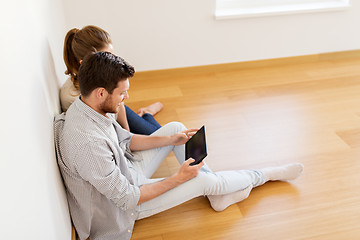 Image showing happy couple with tablet pc computer at new home