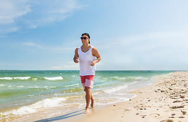 Image showing happy man running along summer beach