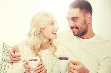 Image showing happy couple with cups drinking tea at home