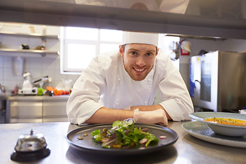 Image showing happy male chef cooking food at restaurant kitchen