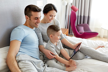 Image showing happy family with tablet pc in bed at home