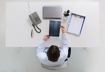 Image showing doctor with spine x-ray sitting at table