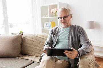 Image showing senior man with tablet pc sitting on sofa at home