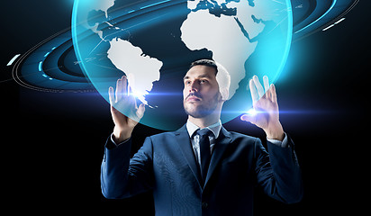 Image showing businessman with earth hologram over black