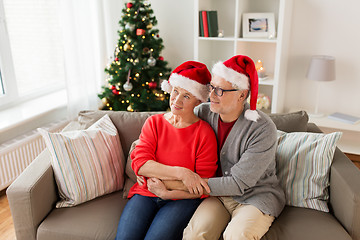 Image showing happy senior couple in santa hats at christmas