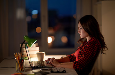 Image showing student or woman typing on laptop at night home