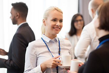 Image showing business people with conference badges and coffee