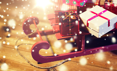 Image showing close up of christmas gift boxes on wooden sleigh