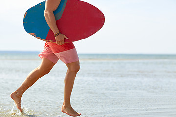 Image showing young man with skimboard on summer beach