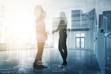 Image showing business people shaking hands over city background