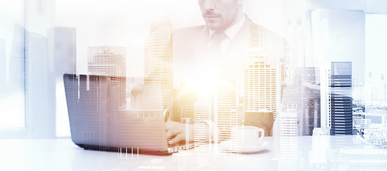 Image showing businessman with laptop and coffee at office