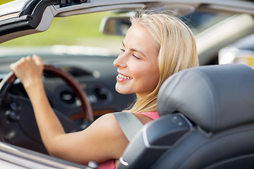 Image showing happy young woman driving convertible car