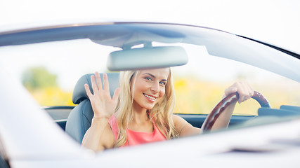 Image showing happy young woman driving convertible car