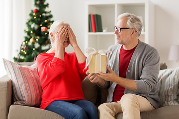 Image showing happy smiling senior couple with christmas gift