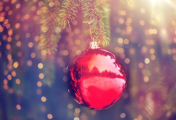 Image showing red christmas ball on fir tree branch with snow