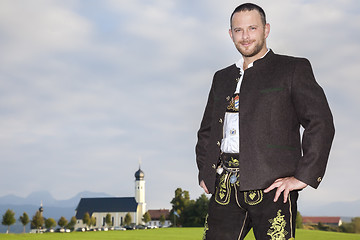 Image showing bavarian tradition man with a church in the background