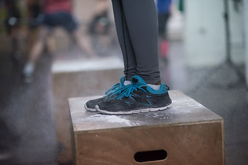 Image showing black woman is performing box jumps at gym