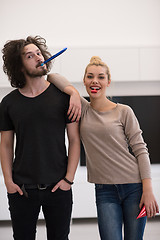 Image showing couple in party hats blowing in whistle